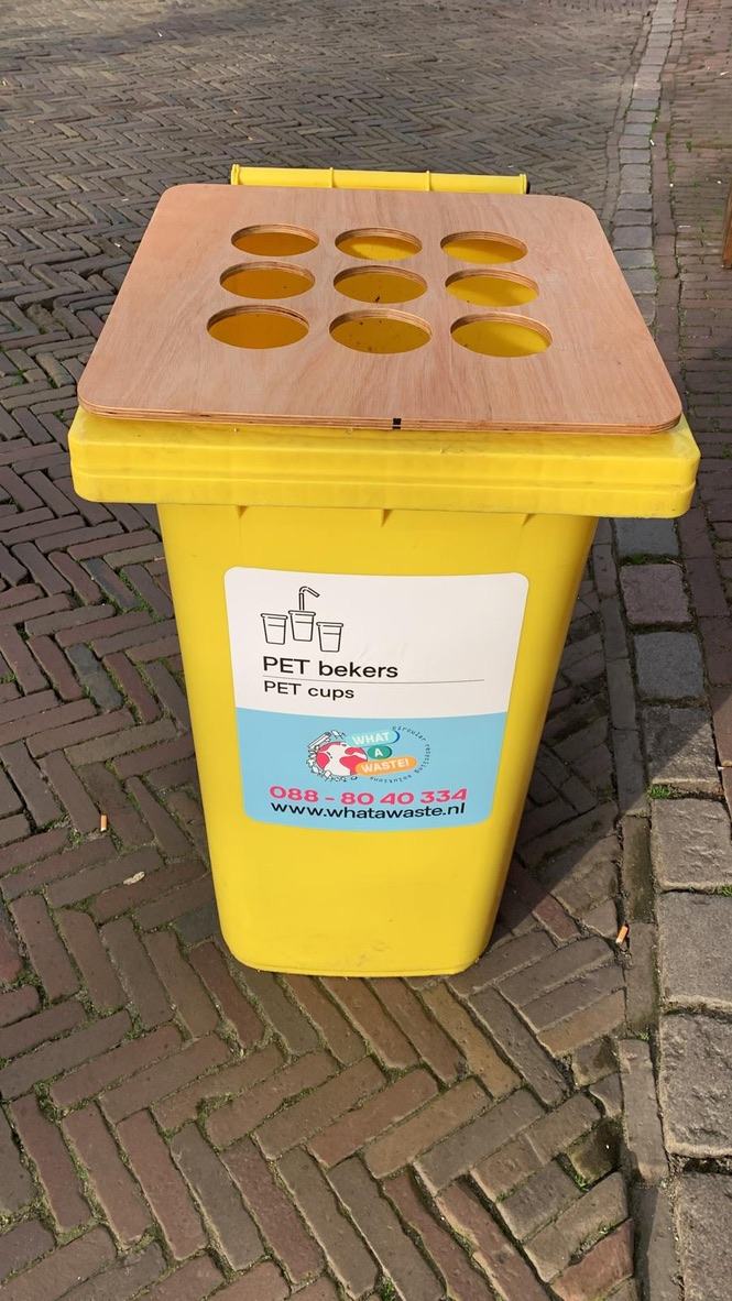 Gele rolcontainer met een houten deksel met bekergaten en een PET bekers-sticker